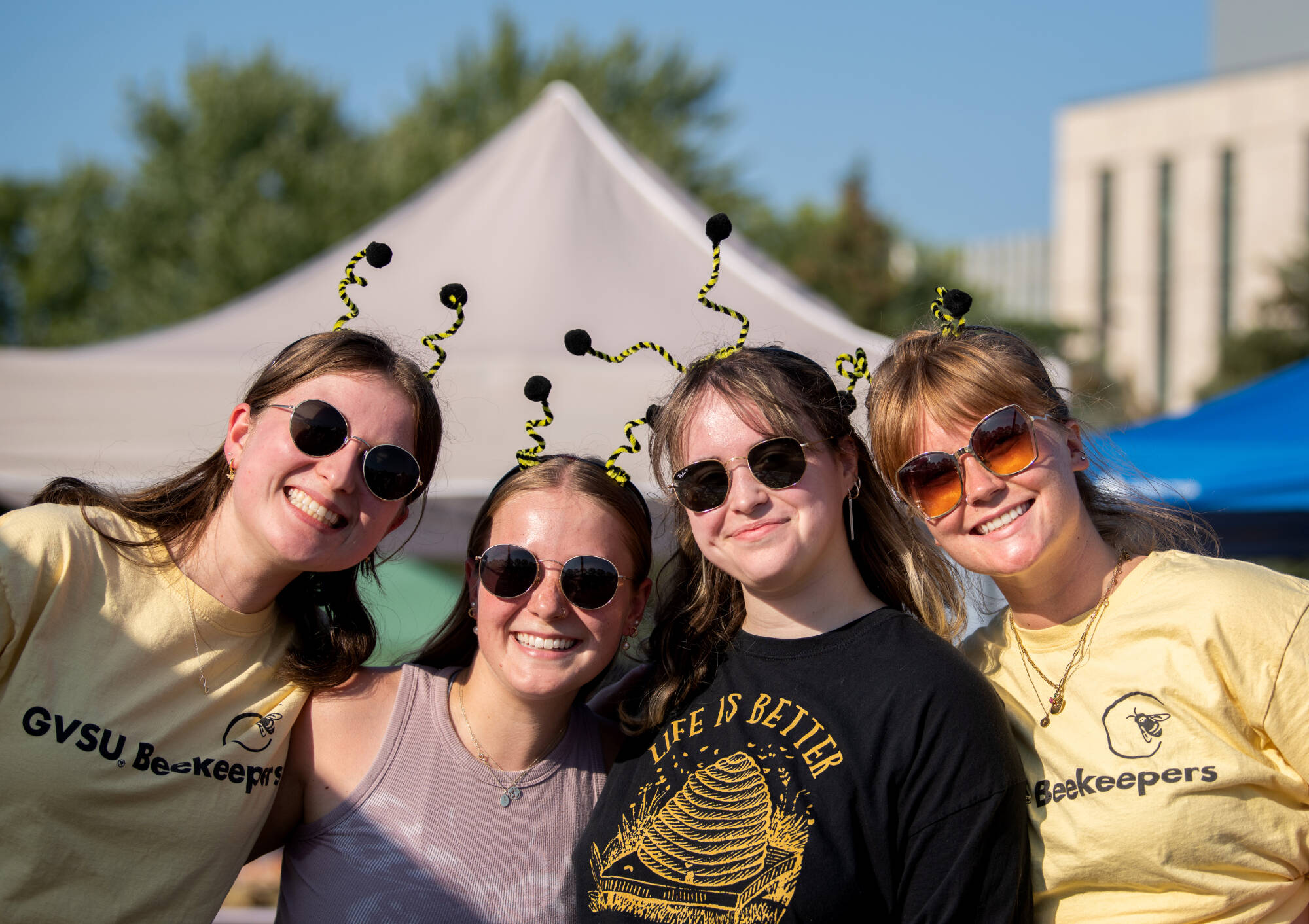 Members of the GVSU Beekeepers, from left, Aida Dennis, Grace deBest, Halle Prynn and Rylee Lorenz pose for a photo while working a table at Campus Night Life August 25. (Photo releases on file)
